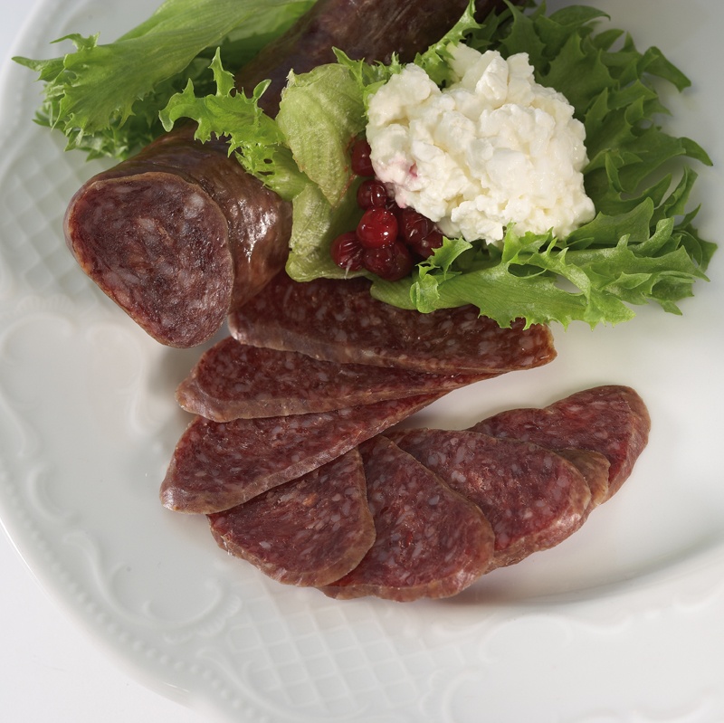 Korgar fylte med spekepølser i ulike variantar på matmarknad.